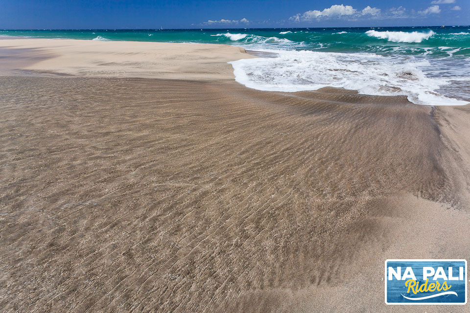 a sandy beach next to the ocean