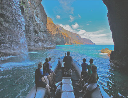 a group of people on a rock next to water